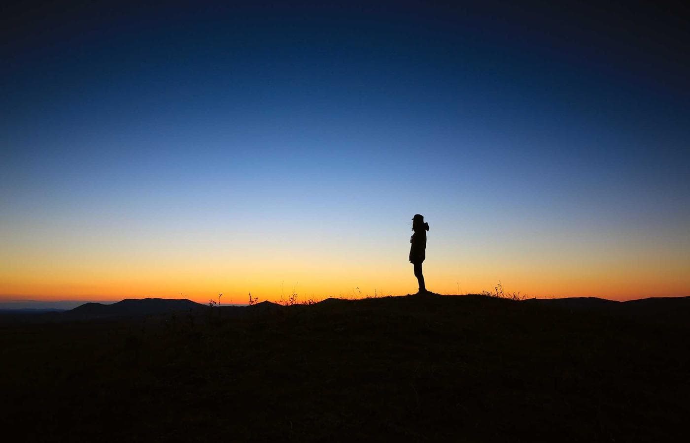 Couple silhouetted against the hills at blue hour